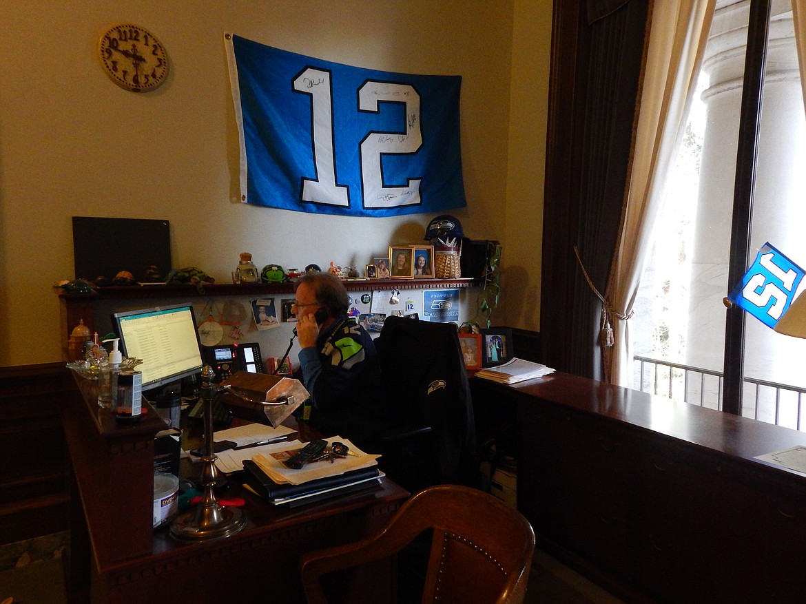 Rebecca White/Columbia Basin HeraldGreg Payne, office coordinator for the chief clerk's office has an array of Seahawks memorabilia at his desk.