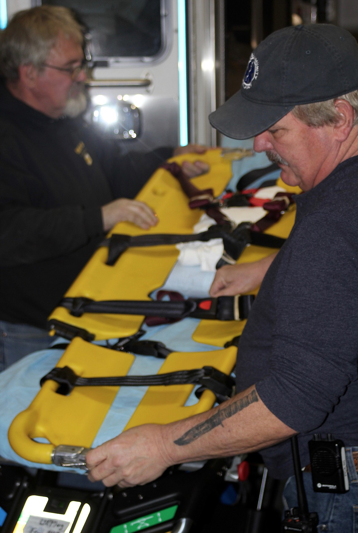 GREG DAVIS and Captain Steve Welty examine a scoop stretcher. (Douglas Wilks/Clark Fork Valley Press)