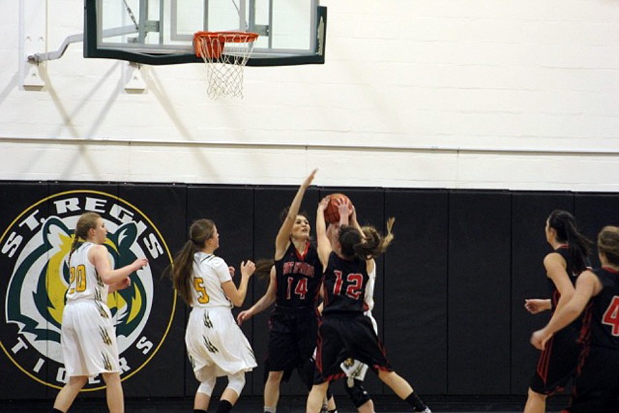 HOT SPRINGS players Danielle Cannon (14) and Sydney Jackson (12) swarm a St. Regis shooter. (Kathy Woodford/Mineral Independent)