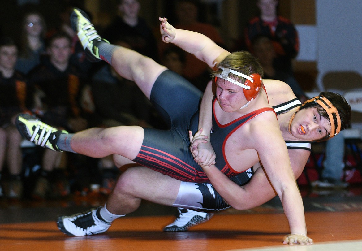 Flathead junior Michael Lee throws Missoula Hellgate junior Dakota Friesen to the mat during the 285-pound match to open the dual at Flathead on Tuesday. Lee pinned Friesen at 1:20 in the first period. (Aaric Bryan/Daily Inter Lake)