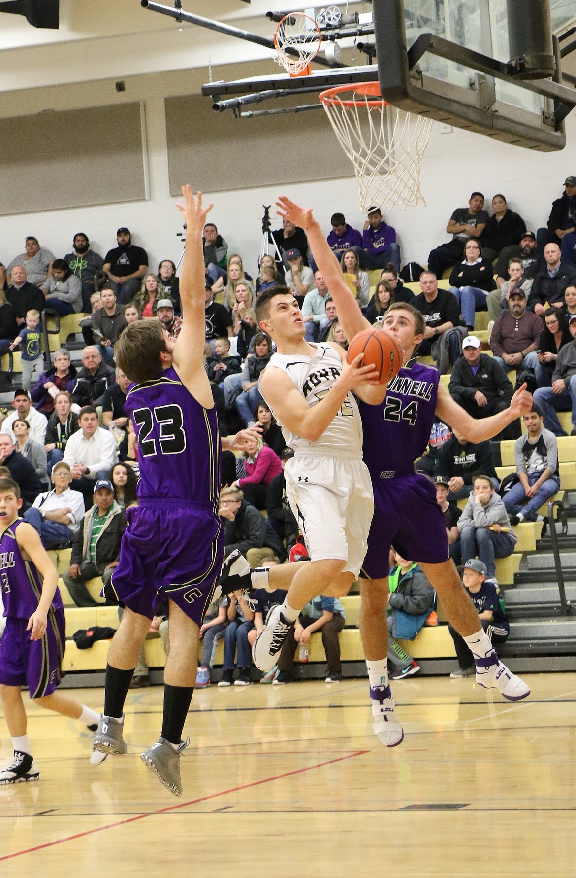 Ted Escobar/The Sun Tribune - Isaac Ellis breaks through the defensive efforts of two Connell boys.