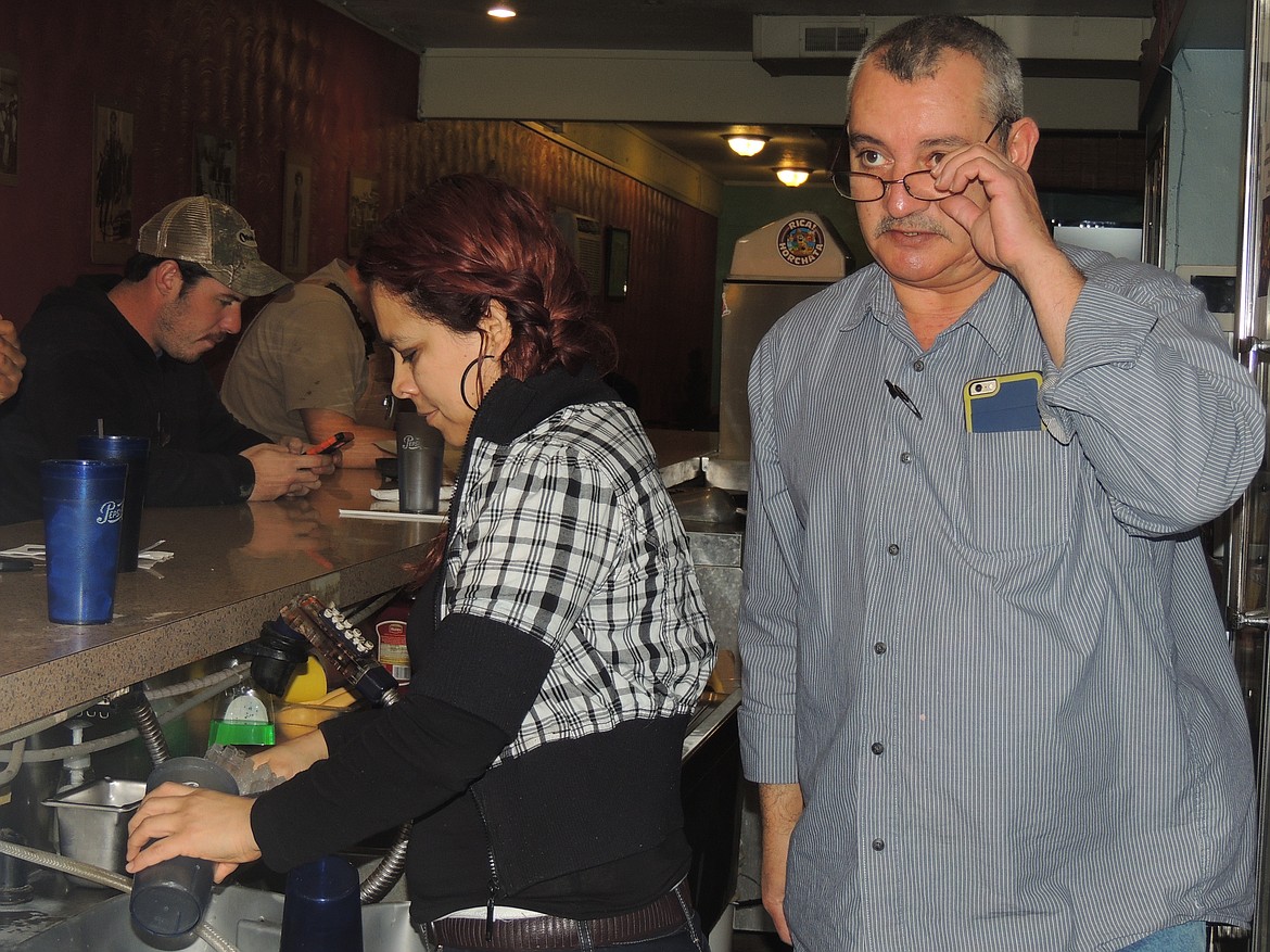 Ted Escobar/The Sun Tribune - Salvador Nu&ntilde;ez, right, attends to customers dining at the lunch bar at the La Caba&ntilde;a restaurant.