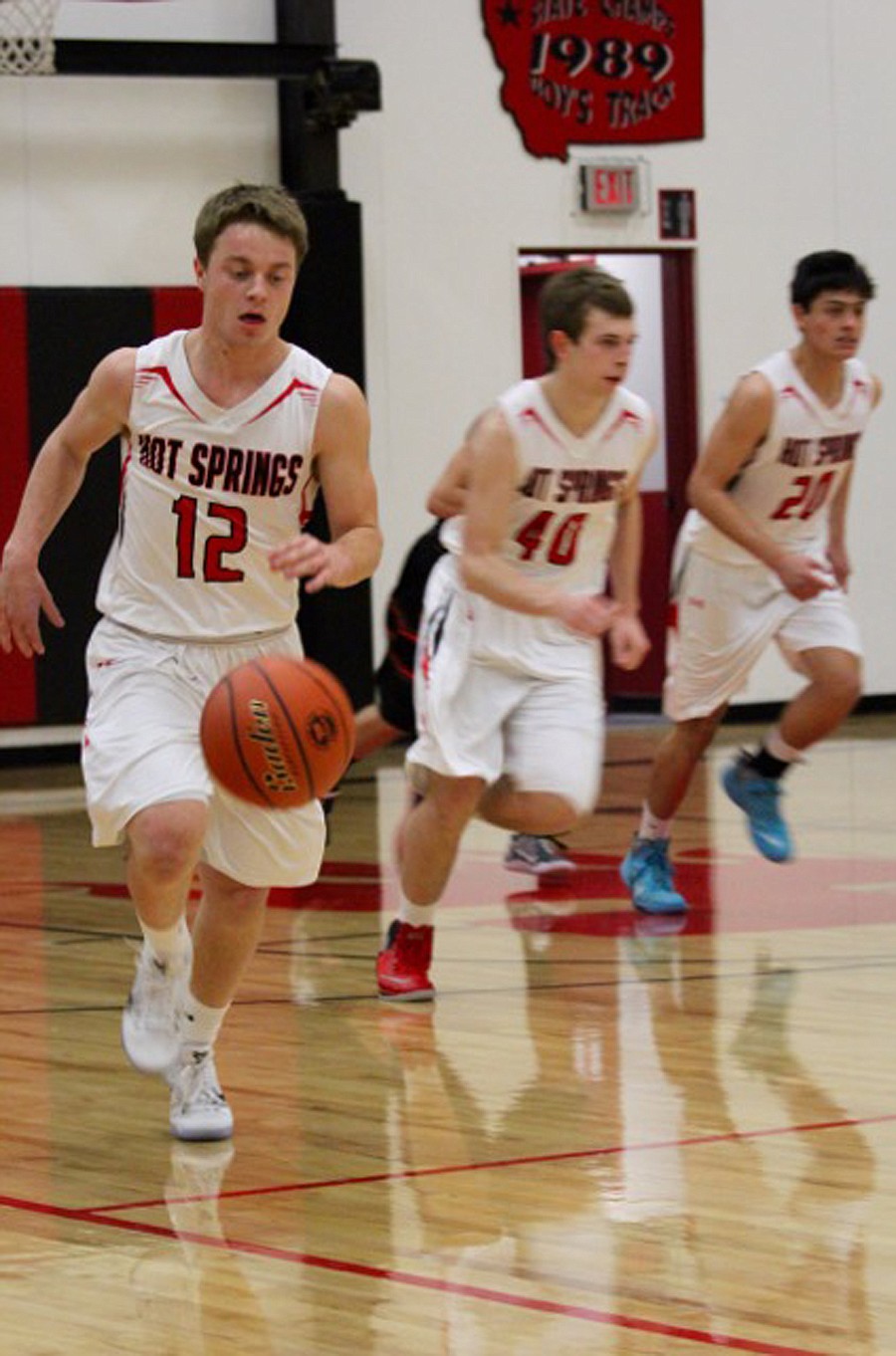 HOT SPRINGS senior Trevor Paro (12) leads Addison Mueller (40) and Pedro Gardemann (20) up the floor on Saturday.