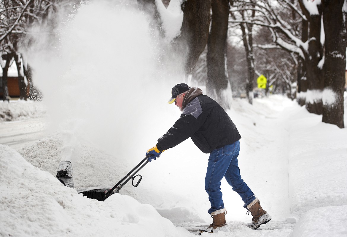 Scott Cobbley clears snow from his sidewalks on Monday afternoon in Kalispell. (Brenda Ahearn photos/Daily Inter Lake)