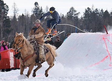 TOME FINLEY rides Sunny as Graham Francis hits a jump during the Whitefish Ski Joring World Invitational on Saturday. The action continues today beginning at noon at the city airport. (Aaric Bryan/Daily Inter Lake)