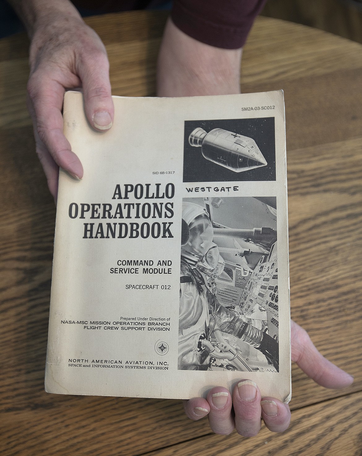 LISA JAMES/ PressRetired engineer and technical writer Vern Westgate holds the Apollo manual which he wrote, as he talks about his experience working for North American Aviation. January 27 is the 50th anniversary of the cabin fire that killed three American astronauts during a pre-launch test for the Apollo 1 mission. As the Apollo was being developed, Westgate was the liaison between the astronauts and the engineers, and got to know them intimately.