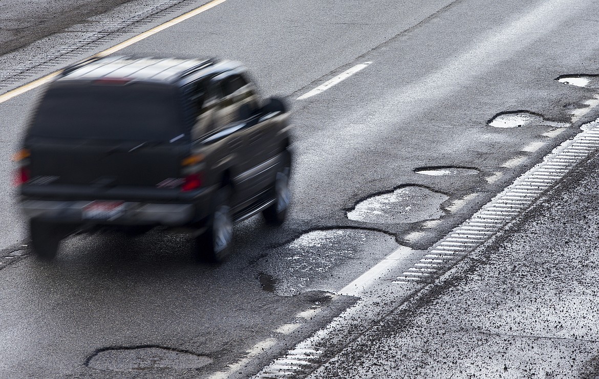 LOREN BENOIT/Press
An SUV drives past potholes in the westbound lanes of Interstate 90 Monday near the Fourth Street on-ramp. From Monday to Thursday night, 7 p.m. to 5 a.m, workers will mill and repave damaged sections along the interstate between Northwest Boulevard and the Sherman Avenue interchange; and between mileposts 15 and 20.