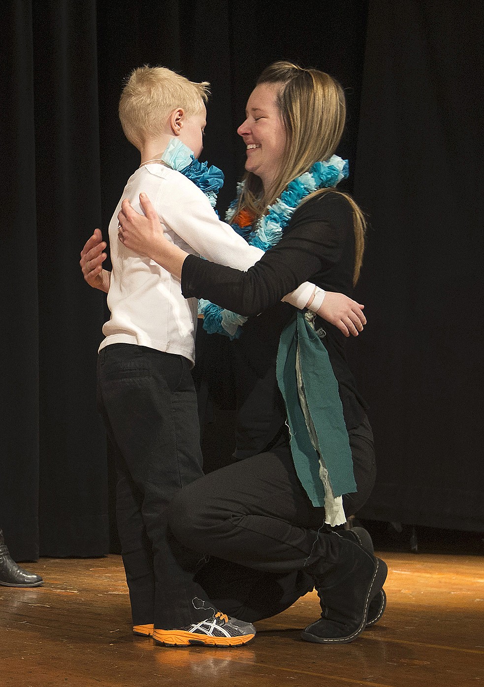 LISA JAMES/ PressSorensen Elementary School artist-in-residence Bria Zan Thompson gets a hug from a kindergartner after being presented with their class lei during Aloha Day  on Friday. As part of the program, students performed different types of Hula, incorporating the lessons in history, culture, legend, language and the natural environment of Hawaii that Thompson shared with them in their lessons.