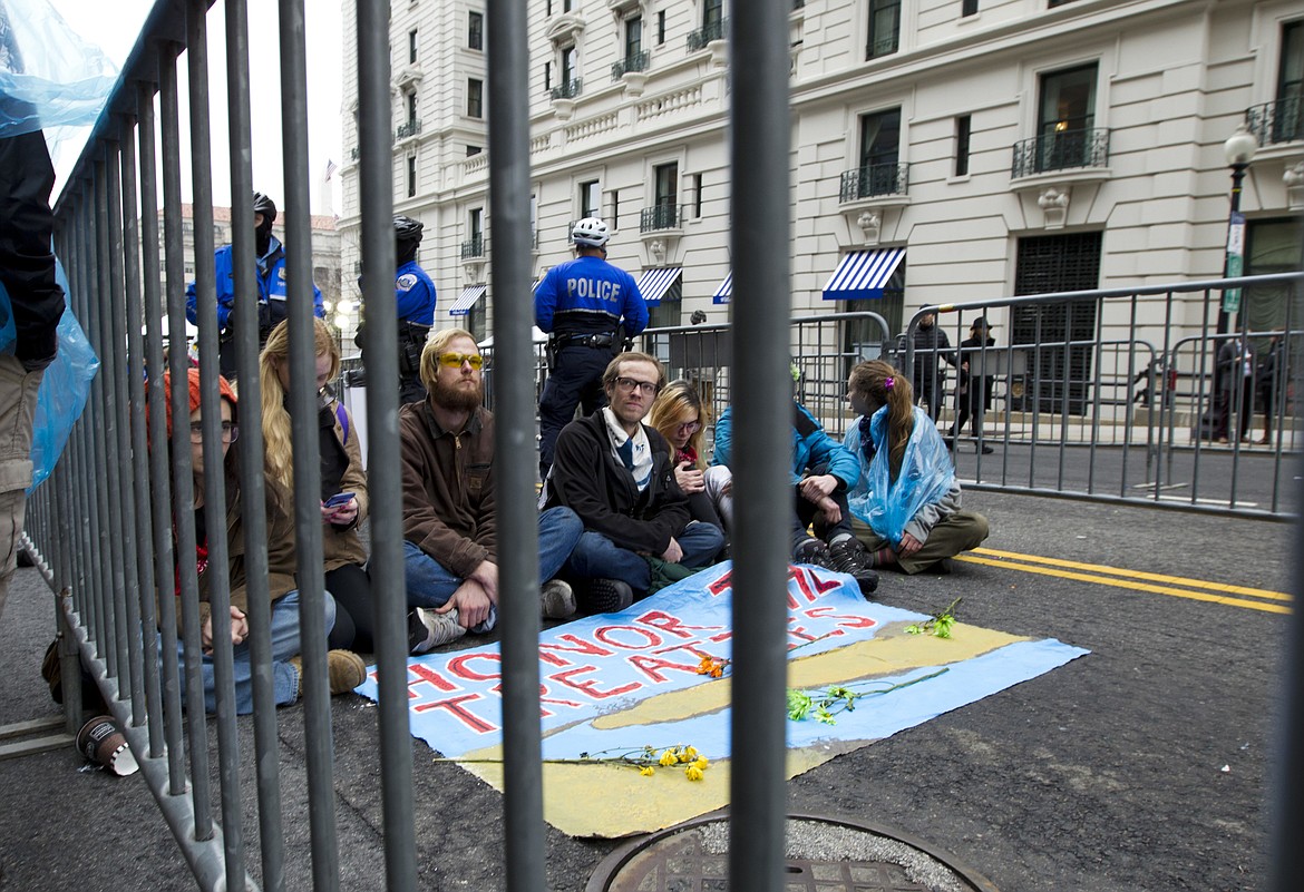 Demonstrators sit at the entrance of a security checkpoint, to block people to enter, Friday, Jan. 20, 2017, during the inauguration of President Donald Trump in Washington. ( AP Photo/Jose Luis Magana)