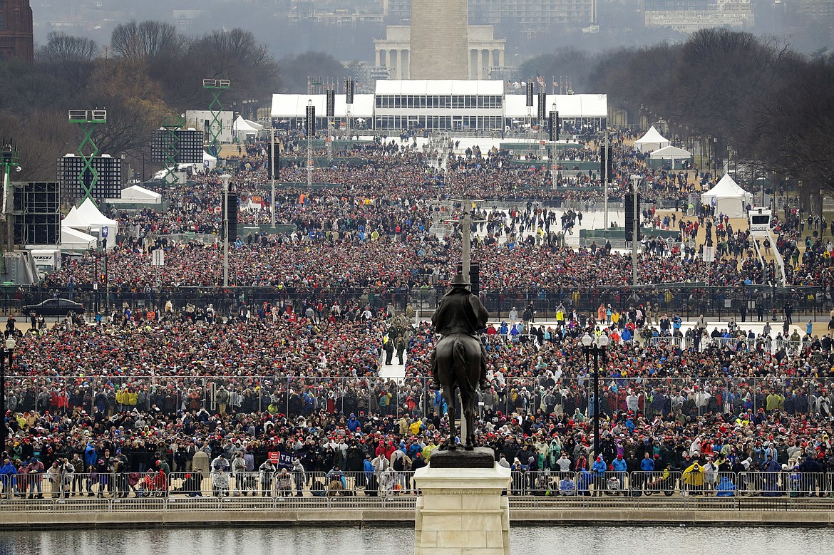 People stand on the National Mall to listen to the 58th Presidential Inauguration for President Donald Trump at the U.S. Capitol in Washington, Friday, Jan. 20, 2017. (AP Photo/Patrick Semansky)