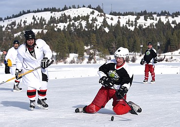 Stuart Swanson of Tamarack shoots from his knees during the Montana Pond Hockey Classic at Foys Lake on Friday. (Aaric Bryan/Daily Inter Lake)