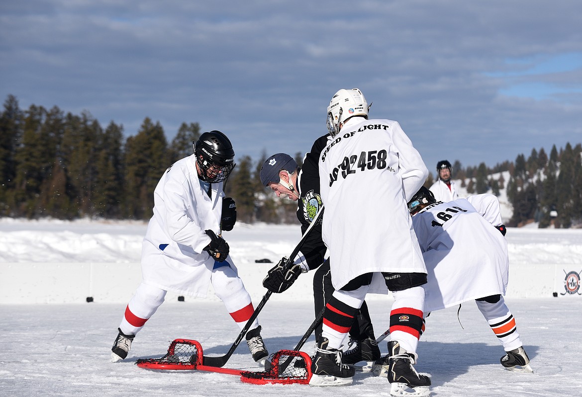 Lanny McDonald scores a goal with a crowd of M=MA defenders around him  during the Montana Pond Hockey Classic at Foys Lake on Friday. (Aaric Bryan/Daily Inter Lake)