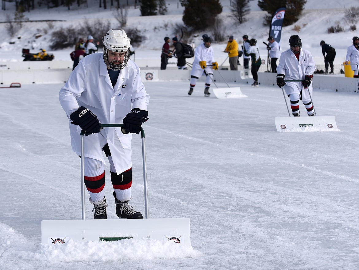 Players on the M=MA team scrape the ice between games during during the Montana Pond Hockey Classic at Foys Lake on Friday. (Aaric Bryan/Daily Inter Lake)
