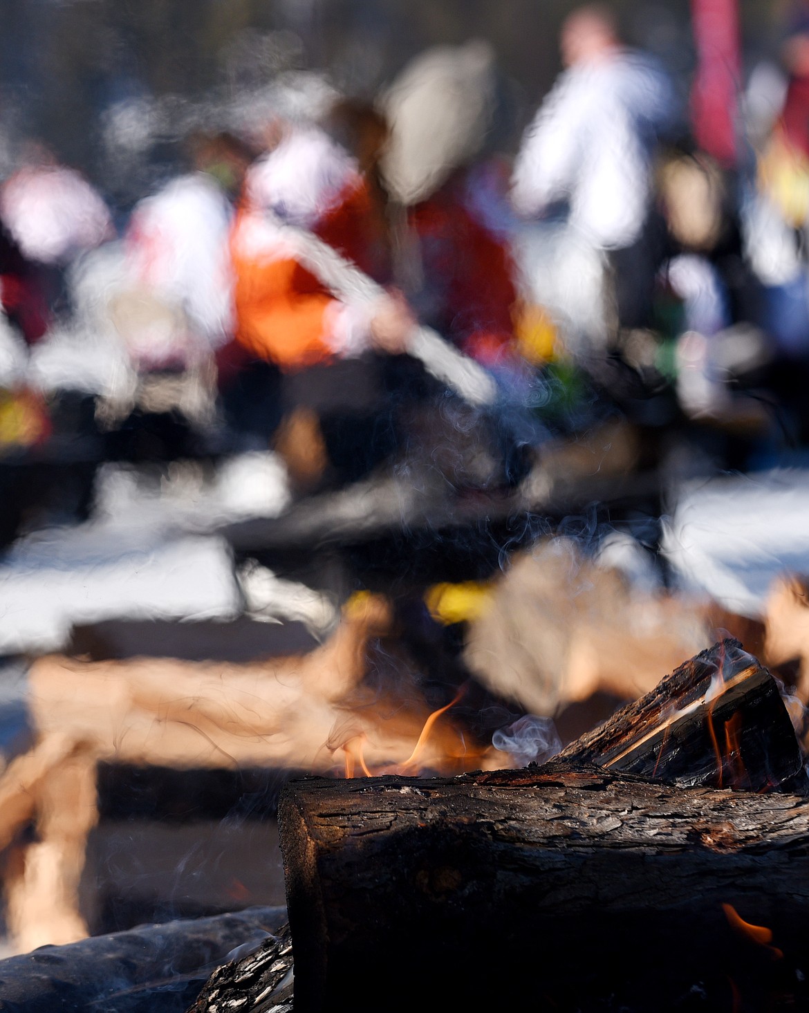 Players warm themselves by the fire during the Montana Pond Hockey Classic at Foys Lake on Friday. (Aaric Bryan/Daily Inter Lake)