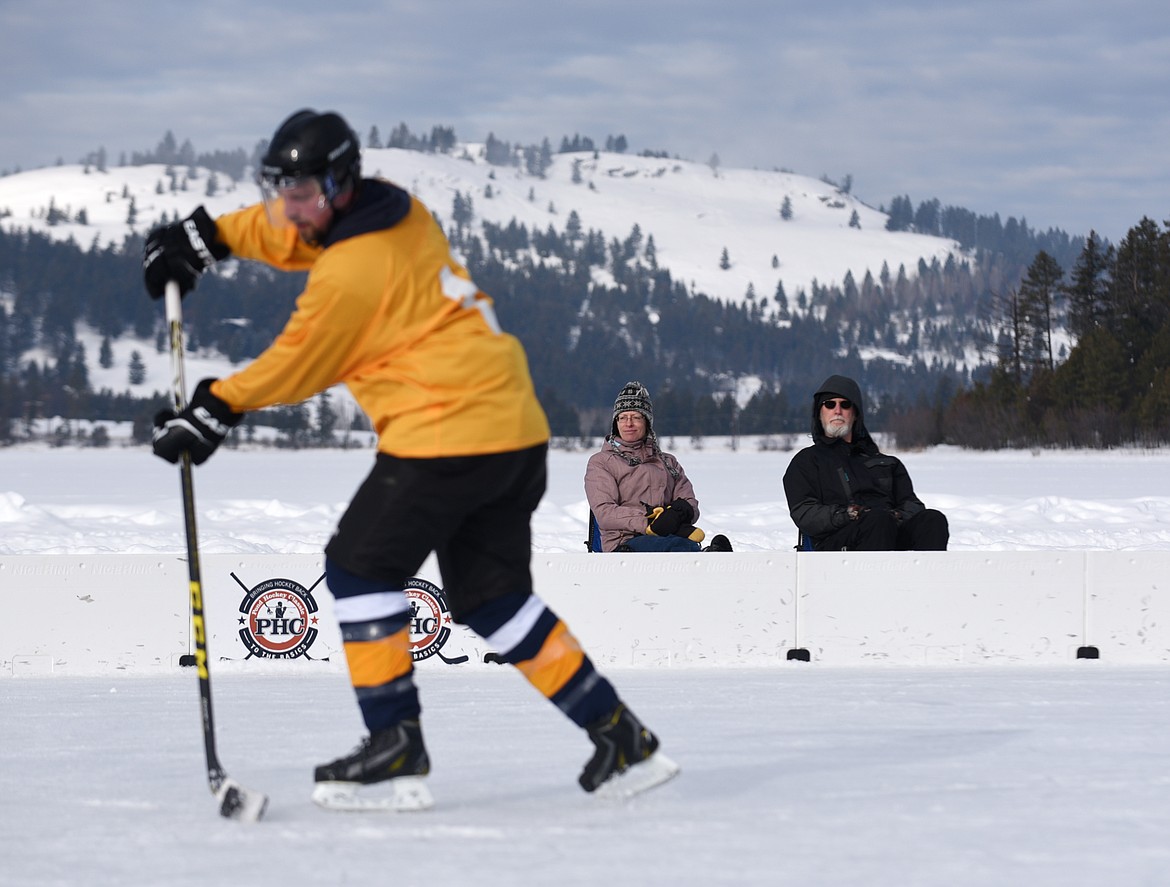 Karen and Pat Heron of Whitefish watch a hockey game during the Montana Pond Hockey Classic at Foys Lake on Friday. (Aaric Bryan/Daily Inter Lake)