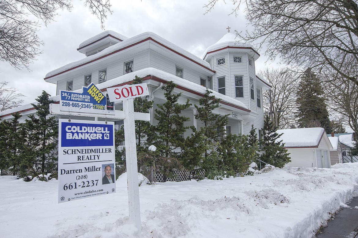 LISA JAMES/ PressA sold sign is pasted over a for sale sign sits outside a combination home/office on Sherman Avenue and 10th Street in downtown Coeur D'Alene on Thursday. Home sales reached a 10-year high in 2016 in  Kootenai County. As prices rise, inventory continues to be lower than demand.