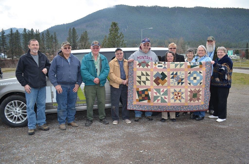 Mineral County Veteran Transportaton members pose in front of the organizations new van with a quilt created by Cabin Fever Quilter, Mary Elderidge. The quilt is a fundraiser for the veteran group. Left to Right: Will Wheeler, Orville Thompson, Doug Cummings, Ken Quitt, Herman Berneking, Mary Eldridge, Gloria Hermes,  Sherrill Christensen, Mary Jo Berry, Glenn Koepke, and Sharon Booth. (Photo courtesy of Mary Jo Berry).