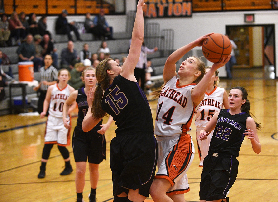 Flathead post Mary Heaton drives in for a shot over Missoula Sentinel&#146;s Kylie Frohlich during the fourth quarter of the Bravettes&#146; 46-43 loss on Tuesday at Flathead High School. (Aaric Bryan/Daily Inter Lake)