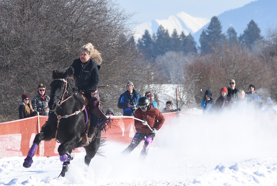 Rider Lynn Hausauer and skier Cole Bower make their final turn during competition Sunday.