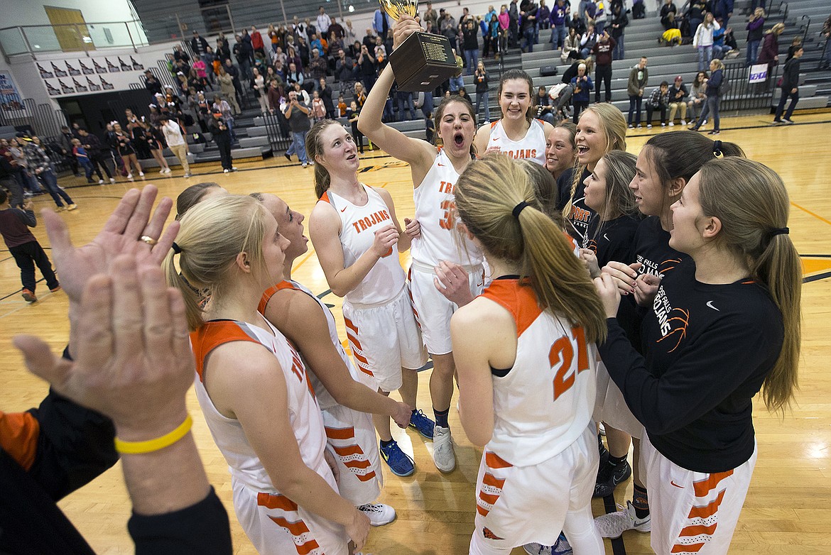 LISA JAMES/ PressMembers of the Post Falls Varsity High School basketball team hold up their 5A Region 1 Championship trophy as they celebrate their 53-39 win over Lewiston High School on Tuesday night at Post Falls High School. In 2 weeks the team goes on to the state championship in Boise.