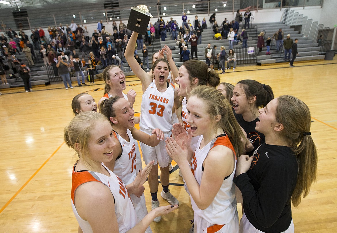 Members of the Post Falls High girls basketball team hold up their 5A Region 1 championship trophy as they celebrate their 53-39 win over Lewiston on Tuesday night at Post Falls High School. Post Falls advances to state next weekend in Nampa.
LISA JAMES/ Press