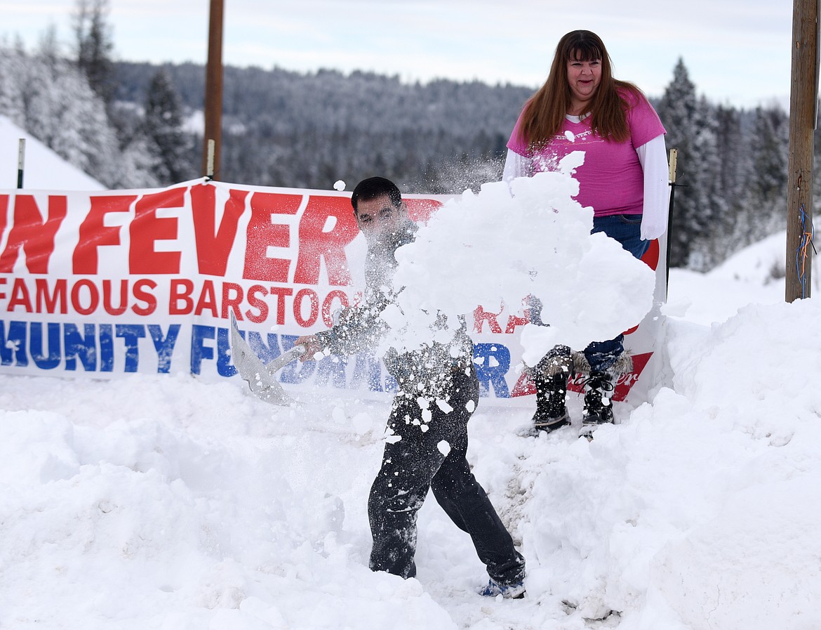 CABIN FEVER Days volunteer organizers Dave Ruis and Kelly Weigant shovel snow in front of the event&#146;s entrance sign in Martin City on Tuesday, Feb. 7, 2017. (Aaric Bryan/This Week in the Flathead)