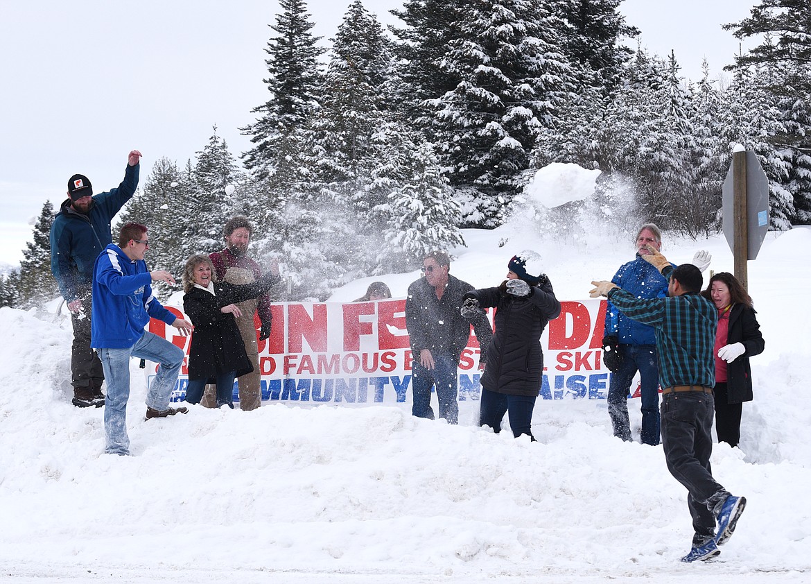 CABIN FEVER Days volunteer organizers take a break to have a snowball fight in front of the event entrance sign in Martin City on Tuesday, Feb. 7, 2017. (Aaric Bryan/This Week in the Flathead)