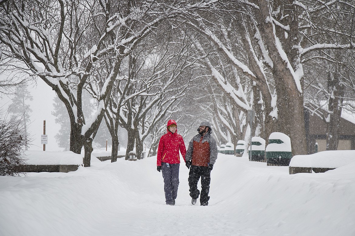 BETHANY BLITZ/PressElizabeth and Carl Pierce of enjoy a quiet morning walk in the snow at City Park on Saturday. The Spokane couple was trying to go to the Lookout Pass ski area, but decided the roads were too dangerous and spent the day in Coeur d&#146;Alene instead.