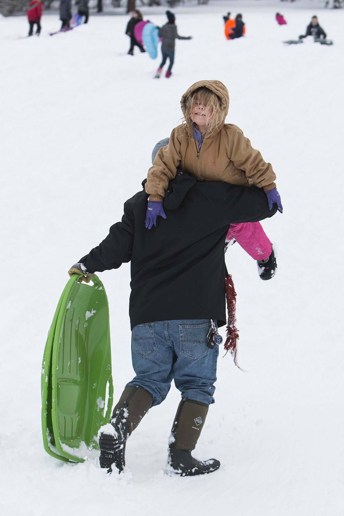 BETHANY BLITZ/PressJimmy Siemers throws high daughter, Zoey, 5, over his shoulder to hike back up the sledding hill Saturday. Siemers said they just moved to Coeur d&#146;Alene and are enjoying their first winter here.