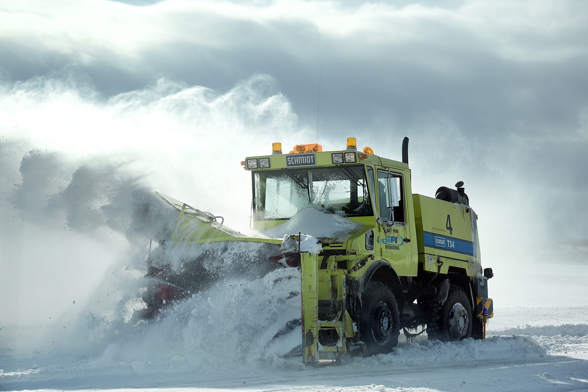 Crews work to clear a taxiway on Monday morning at Glacier Park International Airport. The airport was hit with rain and temperatures in the mid-30s Sunday, which became problematic that night as temperatures dropped and everything iced over. (Brenda Ahearn photos/Daily Inter Lake)