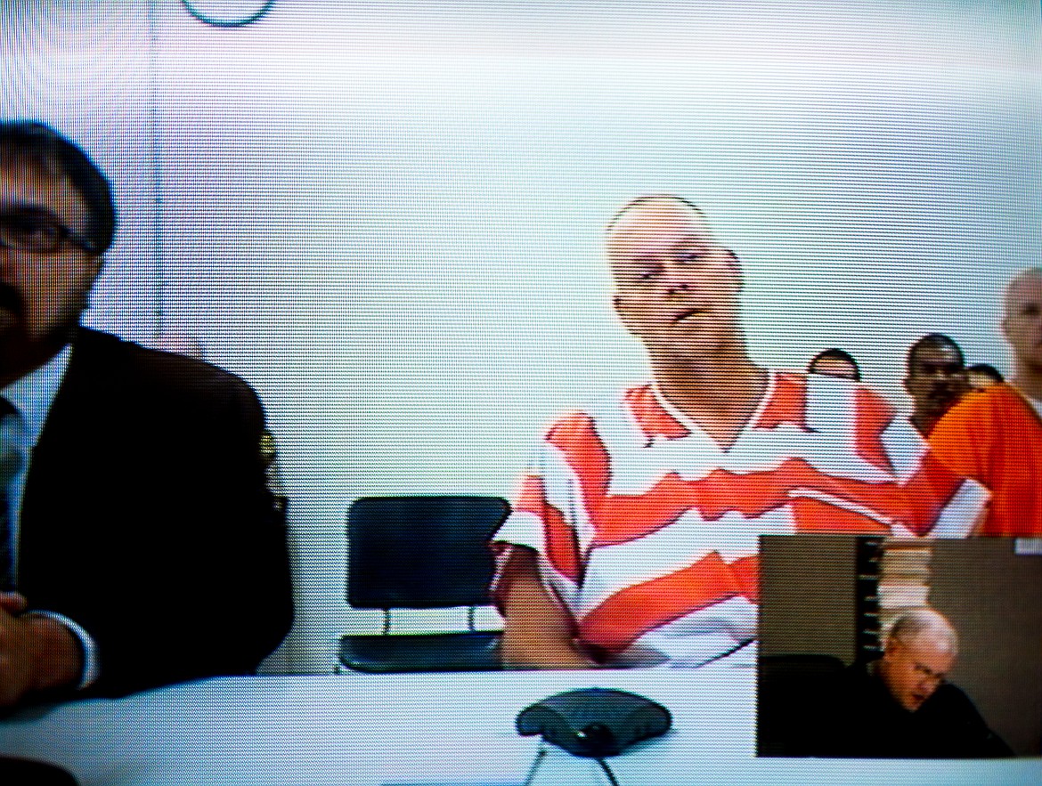 JAKE PARRISH/Press file
David Earl Hutto, 44, is seen on a television screen during a first appearance with Judge James D. Stow at the Kootenai County jail. Hutto pleaded guilty to the killing of Bo Kirk.