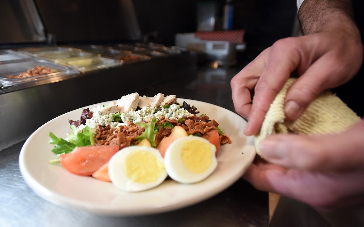 VISCONTI MAKES sure the plate is perfect as he prepares a cobb salad with eggs, tomato, cucumber, bacon, blue cheese and turkey over the house green mix.