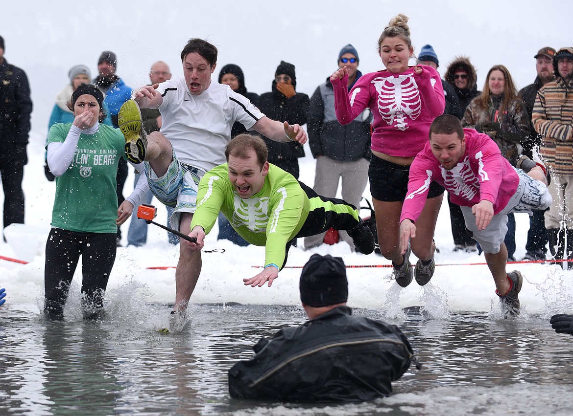 A team gets footage of them taking the plunge during the Penguin Plunge at City Beach on Saturday. (Aaric Bryan/Daily Inter Lake)