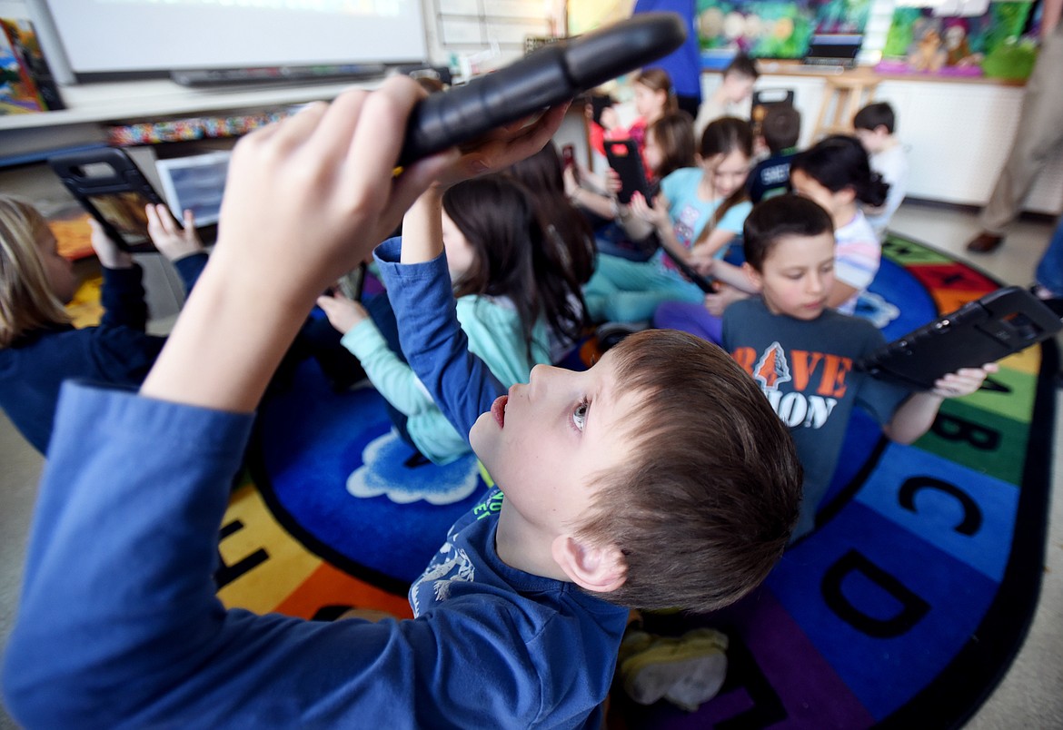 KARL JUST looks up at a tablet on Thursday at Hedges Elementary in Kalispell as he participates in a virtual field trip to ancient Egypt. (Brenda Ahearn/Daily Inter Lake)