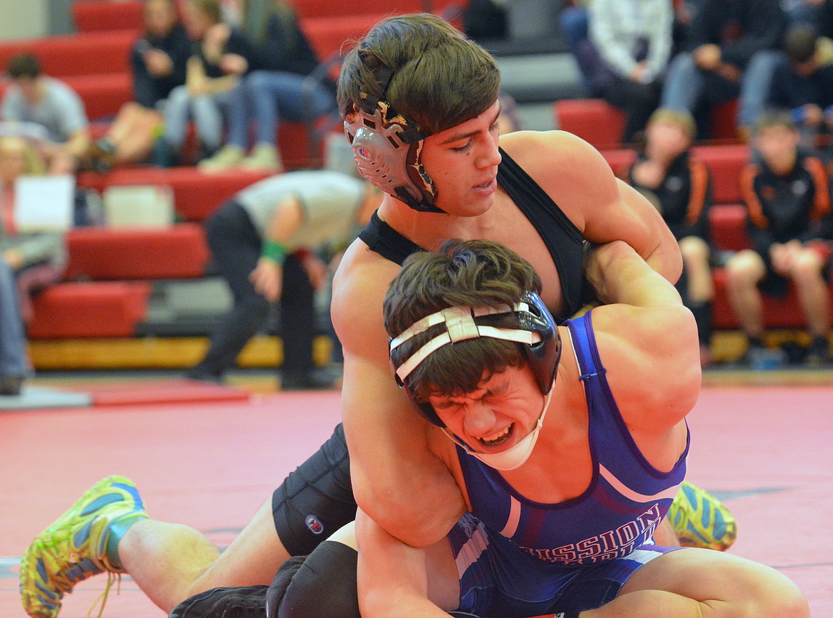 PLAINS WRESTLER Luke Lile attempts to pin Mission-Charlo wrestler Troy Mitchell to the mat in the Western Class B-C Divisional wrestling tournament Saturday afternoon at Arlee High School. (Jason Blasco/Lake County Leader)