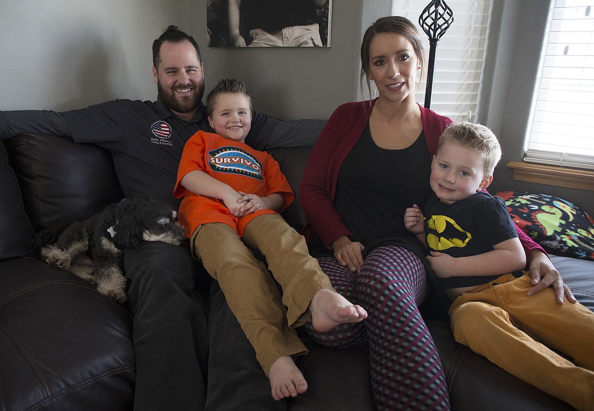 LISA JAMES/ PressTyce Fuqua, left, poses with his parents Keith and Stacy, and his brother Jax at their Hayden home on Tuesday. After 3 years and 3 months of leukemia treatment, Tyce rang the &quot;Cancer free&quot; bell last Thursday, his last day of treatment.