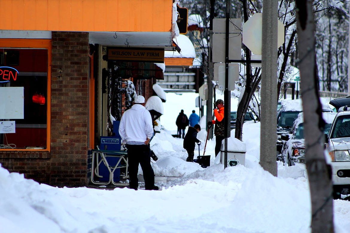 &#151;Photo by STAR SILVA
Downtown Bonners Ferry proprietors shovel walkways and rooftops off of their business on Monday, after heavy snowfall blocks storefronts.