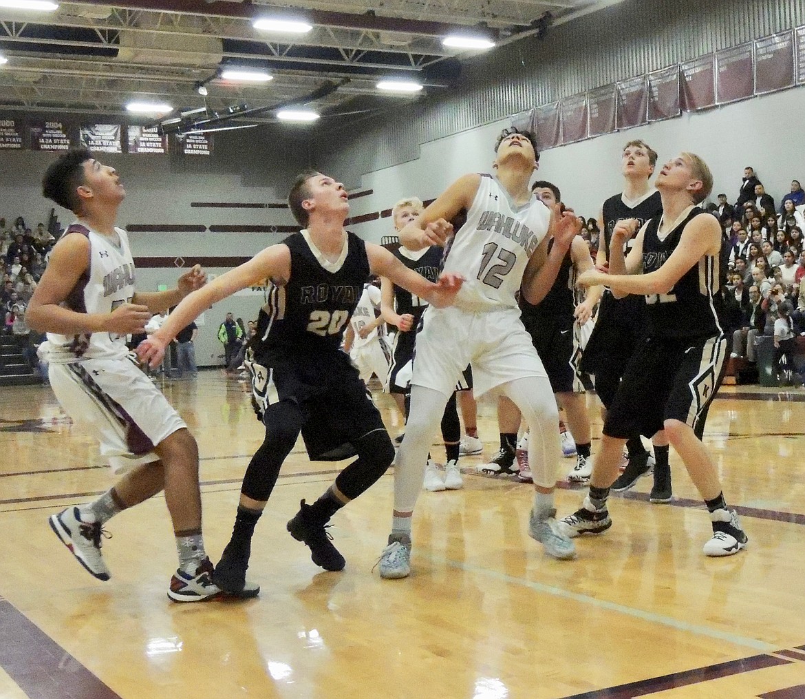 Ted Escobar/The Sun Tribune - Corbin Christensen of Royal and Sergio Pineda and several teammates stake out position as they wait for a rebound to come down in the game at Wahluke Friday.