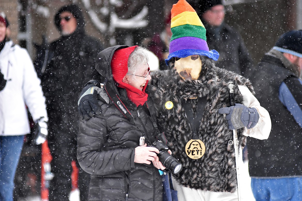 Linda Mundy of Whitefish gets a hug from a Yeti Saturday before the start of the 58th annual Whitefish Winter Carnival Grand Parade. (Heidi Desch/Whitefish Pilot)