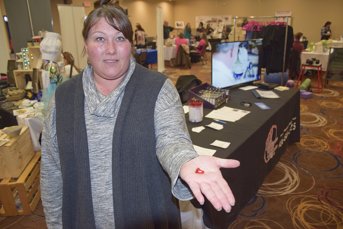 RACHEL GOSS of the Hearing Aid Institute shows of a custom hearing aid at the Lake County Wellness Fair.