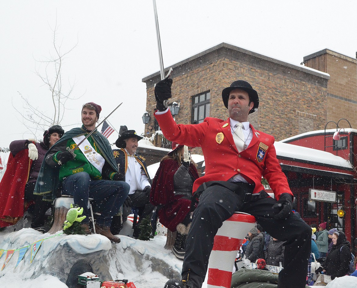 Prime Minister Nick Spear raises is sword on the Winter Carnival royalty float Saturday for the 58th annual Whitefish Winter Carnival Grand Parade. This year&#146;s theme was &#147;One Fish, Two Fish, Whitefish&#148; a nod to the many colorful Dr. Seuss children books. (Heidi Desch/Whitefish Pilot)