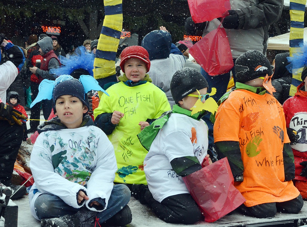 Youngsters ride on the Boy Scout float down Central Avenue Saturday during the 58th annual Whitefish Winter Carnival Grand Parade. This year&#146;s theme was &#147;One Fish, Two Fish, Whitefish&#148; a nod to the many colorful Dr. Seuss children books. (Heidi Desch/Whitefish Pilot)