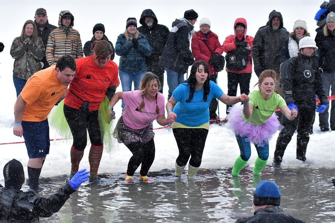 A group jumps into Whitefish Lake Saturday morning during the annual Penguin Plunge at City Beach. The event raises money for Special Olympics Montana. (Heidi Desch/Whitefish Pilot)