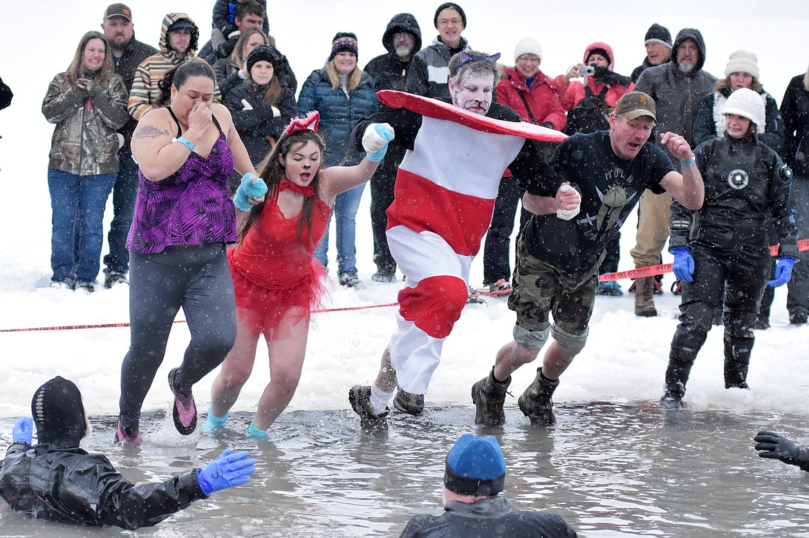 A group jumps into Whitefish Lake Saturday morning during the annual Penguin Plunge at City Beach. The event raises money for Special Olympics Montana. (Heidi Desch/Whitefish Pilot)