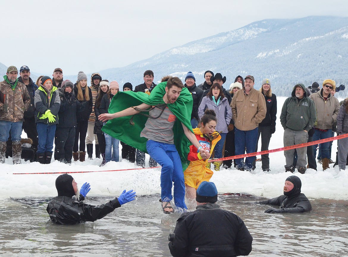 Prince Frey Ethan Mercer and Princess Freya Myah Strauser jump into Whitefish Lake Saturday morning during the annual Penguin Plunge at City Beach. The event raises money for Special Olympics Montana. (Heidi Desch/Whitefish Pilot)