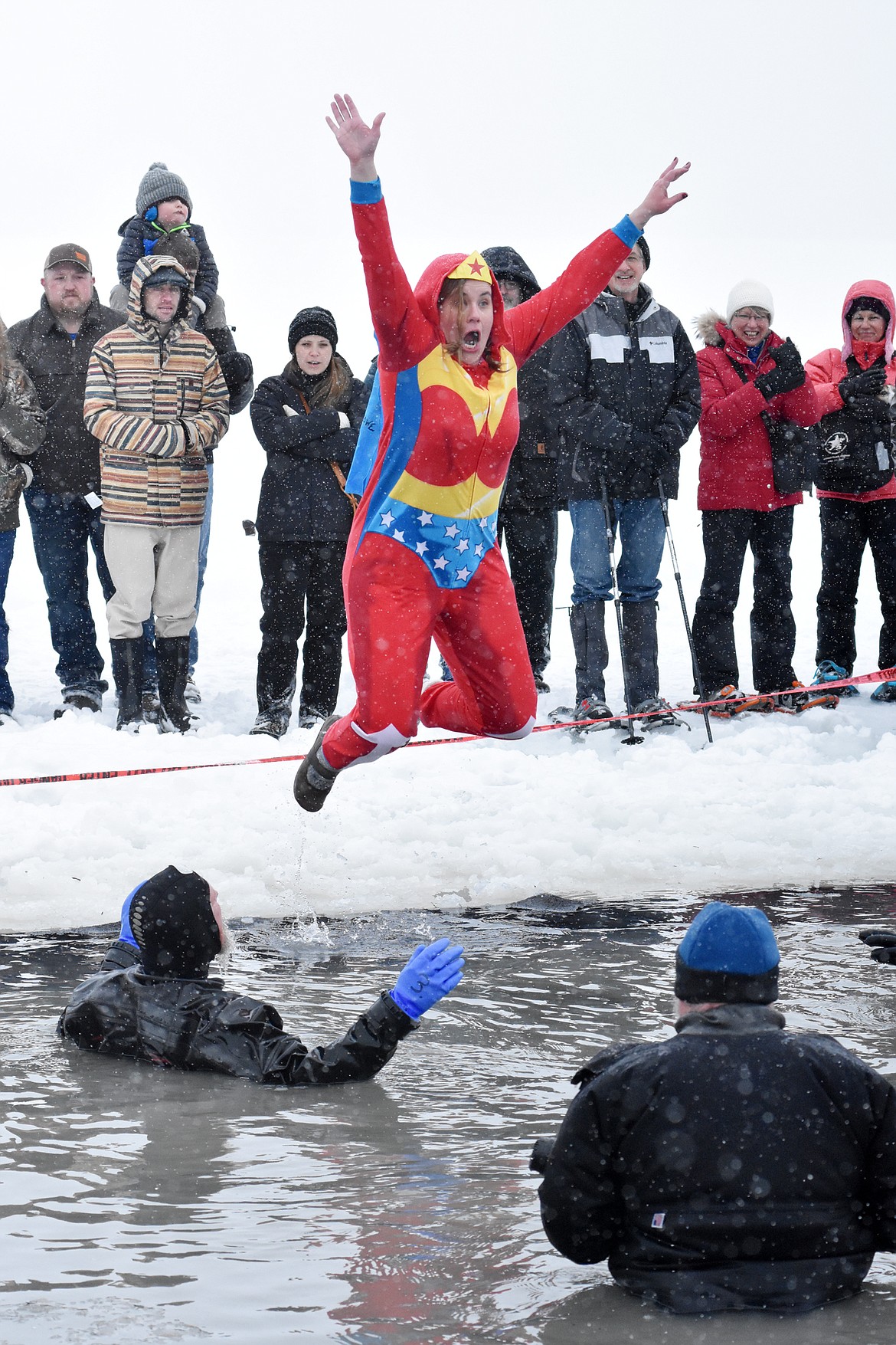 Wonder Woman jumps into Whitefish Lake Saturday morning during the annual Penguin Plunge at City Beach. The event raises money for Special Olympics Montana. (Heidi Desch/Whitefish Pilot)