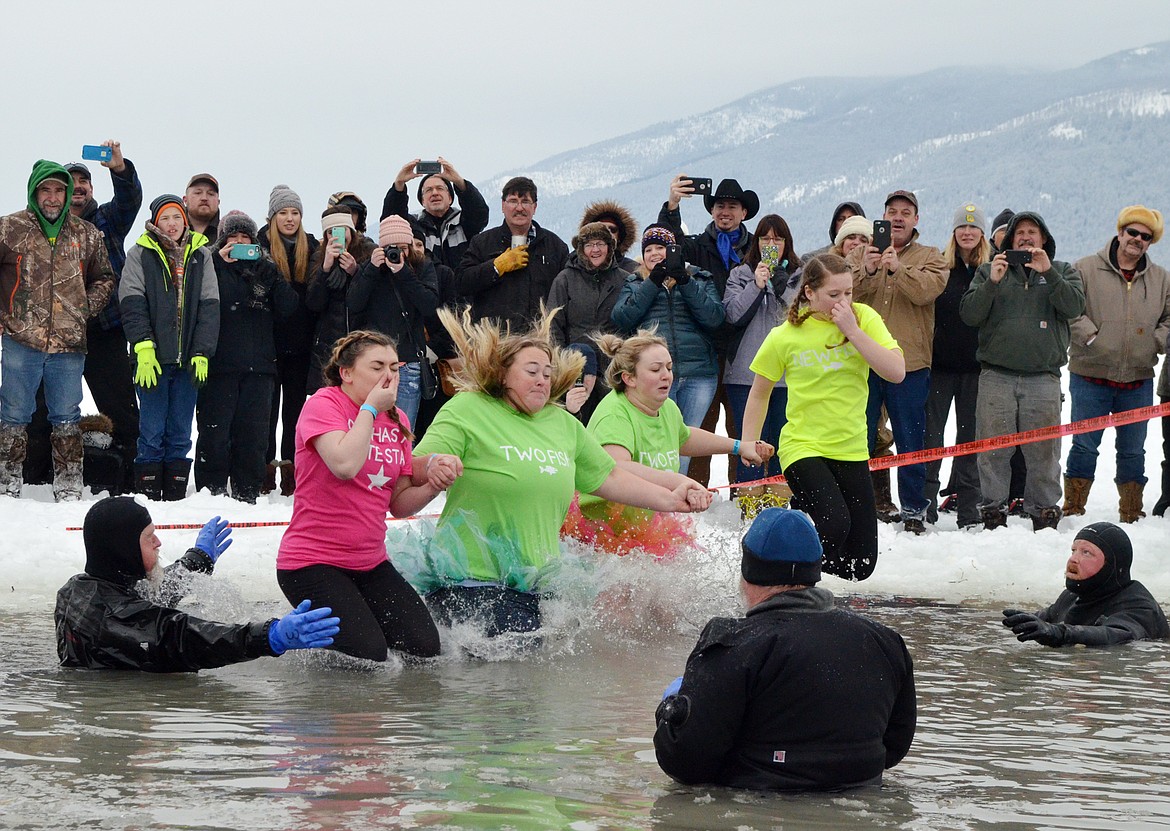 A group jumps into Whitefish Lake Saturday morning during the annual Penguin Plunge at City Beach. The event raises money for Special Olympics Montana. (Heidi Desch/Whitefish Pilot)