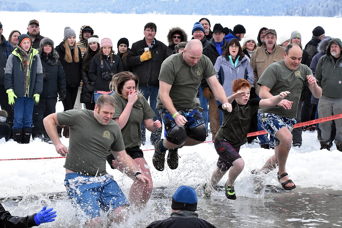 The Montana Highway Patrol team jumps into Whitefish Lake Saturday morning during the annual Penguin Plunge at City Beach. The event raises money for Special Olympics Montana. (Heidi Desch/Whitefish Pilot)