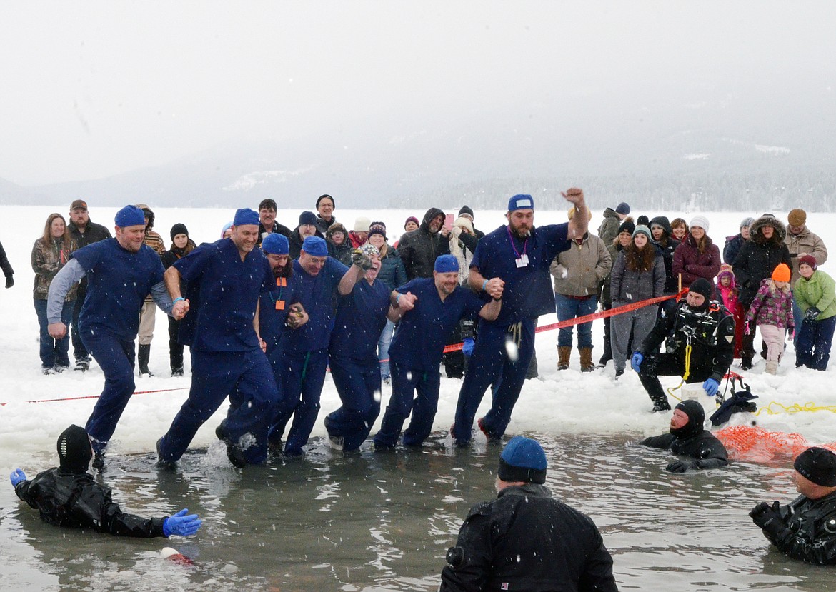 A group from North Valley Hospital jumps into Whitefish Lake Saturday morning during the annual Penguin Plunge at City Beach. The event raises money for Special Olympics Montana. (Heidi Desch/Whitefish Pilot)