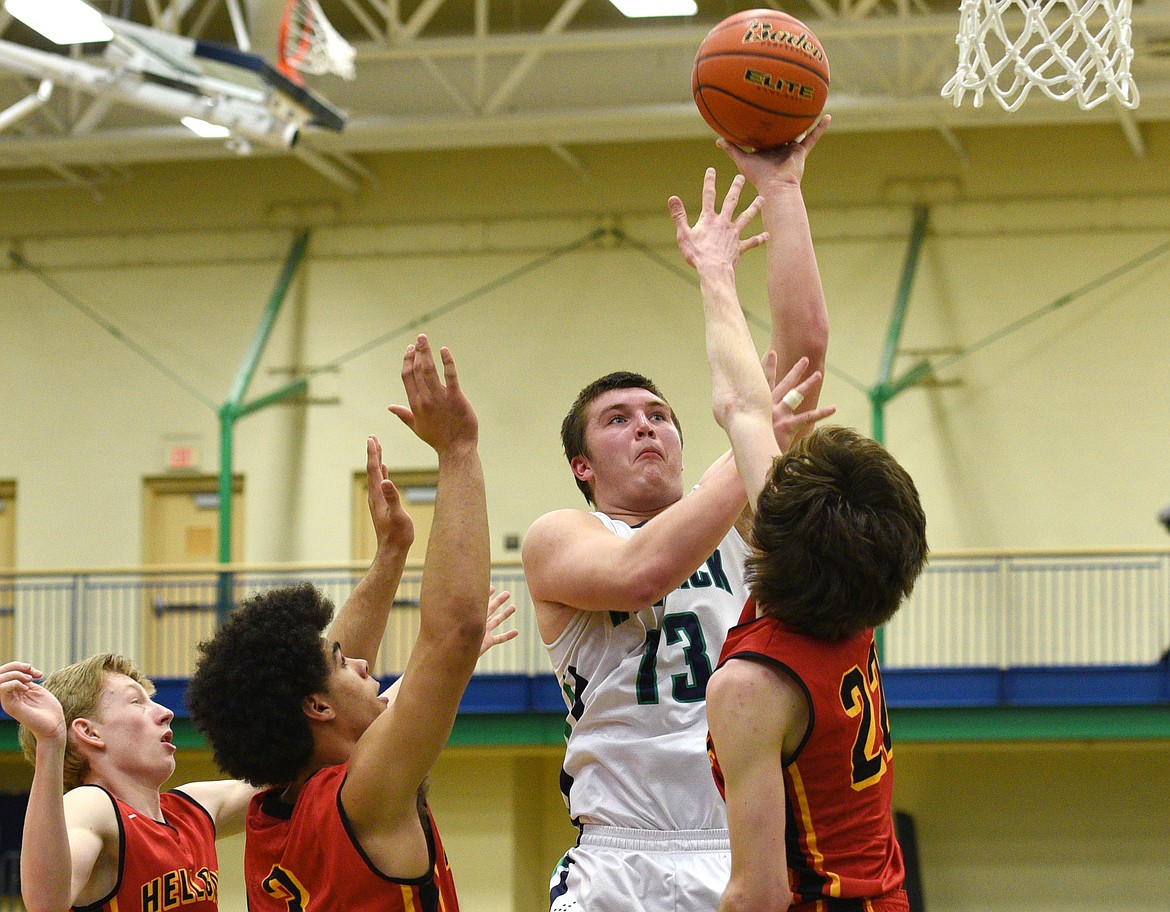 Glacier post Jaxen Hashley floats up a shot in a crowd of Missoula Hellgate defenders during the first half at Glacier on Saturday. (Aaric Bryan/Daily Inter Lake)